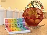 A weekly pill organizer on a kitchen counter